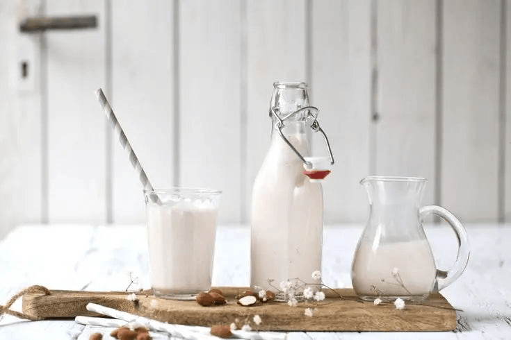 A variety of milk and packaged dairy items displayed neatly on shelves in a grocery store.