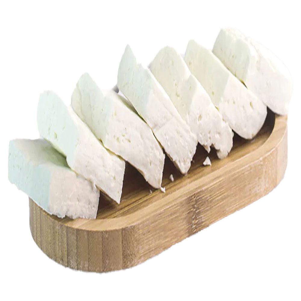 Fresh Syrian Nabulsi Cheese Low Salt, 250g  on a wooden cutting board, showcasing its creamy texture and traditional appearance.